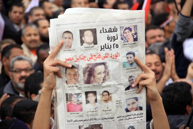 یکی از معترضین در میدان التحریر در ماه فوریه 2011، روزنامه ای را در دست دارد که در آن نوشته شده است "گل در مصر شکوفه می دهد"