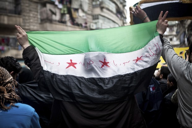 یک مرد سوری پرچم انقلاب سوریه را در دست دارد - عکس از خبرگزاری اسوشیتد پرس