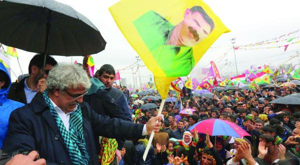 یکی از نامزدهای انتخابات پارلمانی حزب کردستان ترکیه در جشن عید نوروز در دیار بکر تصویری از اوجالان را به دست دارد (عکس از آسوشیتد پرس)
