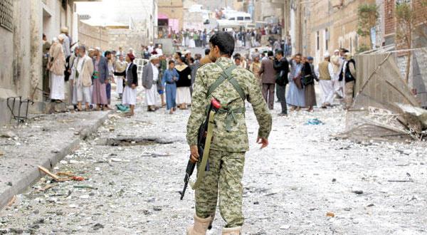 یک فرد مسلح از پیروان حوثی در حال راه رفتن مقابل محل انفجار خودروری بمب گذاری شده که مسجد پیروان مذهب اسماعیلی را در صنعا هدف قرار داد – عکس از آژانس عکس خبری اروپا