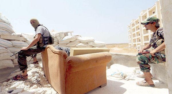 دو مبارز از «جبهه النصره» در حال استراحت پشت کیسه های شن در محله شیخ مقصود در شهر حلب – عکس از رویترز