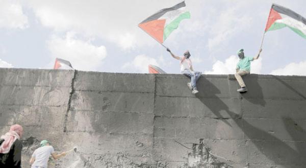 یک تظاهر کننده فلسطینی که در پی درگیری با سربازان فلسطینی در روستای ابودیس در شرق قدس سعی دارد در دیوار حائل یک شکاف ایجاد کند – عکس از رویترز