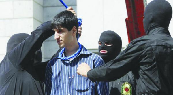یک پلیس ایرانی در حال انداختن طناب دار به گردن یک جوان در تهران – عکس از گیتی
