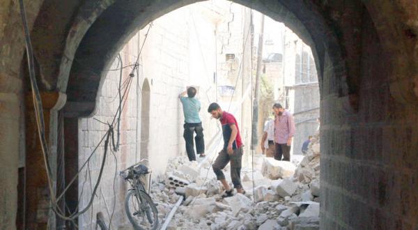 ساکنان محله های قدیمی شهر حلب در حال بررسی ویرانی های به جا مانده در منطقه سکونت خود در اثر بمباران جنگنده ها – عکس از رویترز